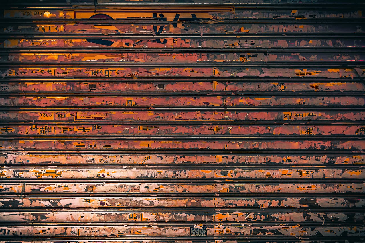 A close-up of a rusty metal shutter adorned with colorful graffiti in Hong Kong, ideal for urban art themes.